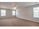 Spacious primary bedroom with carpet, ceiling fan and windows for lots of natural light at 1015 Lakeside Cir, Covington, GA 30016