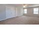 Primary bedroom with carpet, ceiling fan, dual closets and multiple windows at 1015 Lakeside Cir, Covington, GA 30016