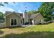Home featuring a well-maintained backyard, a patio with furniture, and lush green grass at 130 Lacey Oak Ln, Loganville, GA 30052