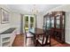 Dining room with a chandelier, large cabinet, and a window with natural lighting at 130 Lacey Oak Ln, Loganville, GA 30052