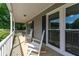 Relaxing front porch area with classic white rocking chairs and nice view of the front yard at 130 Lacey Oak Ln, Loganville, GA 30052