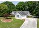 Inviting home with a manicured lawn, lush greenery, and an asphalt driveway, exuding charm and elegance at 130 Lacey Oak Ln, Loganville, GA 30052