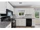A close-up view showcasing kitchen appliances and sleek white cabinets with modern countertops at 130 Lacey Oak Ln, Loganville, GA 30052