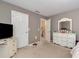 Bedroom with white dresser and trim, neutral carpet and walls, plus a closet and television at 3265 Watson Gate Rd, Loganville, GA 30052