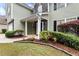 Inviting entryway with manicured landscaping, a walkway, and a front door with stone accents on the two-story home at 3265 Watson Gate Rd, Loganville, GA 30052