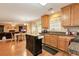 Open kitchen featuring wooden cabinets, granite counters, and an island with an adjacent living room and dining area at 3265 Watson Gate Rd, Loganville, GA 30052