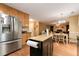 Kitchen with wooden cabinets, stainless steel refrigerator, and moveable island open to the dining and living areas at 3265 Watson Gate Rd, Loganville, GA 30052