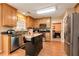 Cozy kitchen featuring warm wood cabinets, granite countertops, stainless steel dishwasher and refrigerator, plus a moveable island at 3265 Watson Gate Rd, Loganville, GA 30052