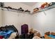 Image shows a messy walk-in closet with wire shelving filled with books, boxes, and luggage at 3265 Watson Gate Rd, Loganville, GA 30052