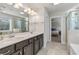 Bright bathroom with a double vanity, glass shower and a glimpse into the primary bedroom at 3560 Summerpoint Xing, Cumming, GA 30028