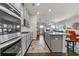Modern kitchen with stainless steel appliances, gray cabinets, island, and open layout to living room at 3560 Summerpoint Xing, Cumming, GA 30028