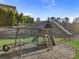 Community playground with a slide, swings, and a large tunnel slide on a grassy hill at 3560 Summerpoint Xing, Cumming, GA 30028
