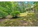 Spacious backyard featuring a large grassy area, mature trees, and a grassy hill at 3663 Homewood Trl, Powder Springs, GA 30127