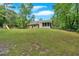 Expansive backyard with lush green lawn, mature trees, play structure, and fenced perimeter at 3663 Homewood Trl, Powder Springs, GA 30127