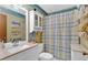 Well-lit bathroom with white vanity, sink and a shower with a blue patterned curtain at 3663 Homewood Trl, Powder Springs, GA 30127