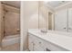 Well-lit bathroom with white vanity, ample storage, a framed mirror, and a shower-tub combo at 11715 Dancliff Trce, Alpharetta, GA 30009