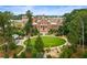 Aerial view of a park featuring a circular lawn, a pond, and sculptures, surrounded by trees and buildings at 11715 Dancliff Trce, Alpharetta, GA 30009