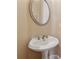 Stylish powder room with brushed nickel fixtures and oval mirror at 11715 Dancliff Trce, Alpharetta, GA 30009