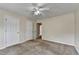 Bedroom featuring neutral colored walls and carpet and three doors, and a ceiling fan with lights at 1405 Bramlett Forest Trl, Lawrenceville, GA 30045