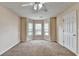 Bright bedroom featuring neutral colored walls and carpet and a charming window nook with three windows at 1405 Bramlett Forest Trl, Lawrenceville, GA 30045
