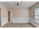 Traditional dining room has wainscoting, a chandelier, and a window for natural light at 1405 Bramlett Forest Trl, Lawrenceville, GA 30045
