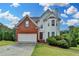 Charming two-story home features brick and vinyl siding with an attached two-car garage at 1405 Bramlett Forest Trl, Lawrenceville, GA 30045