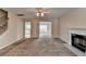 Open-concept living room view showcases fireplace, neutral carpet, and open access to adjacent rooms at 1405 Bramlett Forest Trl, Lawrenceville, GA 30045