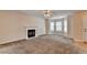 Spacious living room with a fireplace, large bay window, ceiling fan, and neutral carpeting at 1405 Bramlett Forest Trl, Lawrenceville, GA 30045