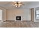 Spacious living room featuring fireplace, ceiling fan, and neutral carpet, creating a welcoming ambiance at 1405 Bramlett Forest Trl, Lawrenceville, GA 30045