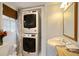 Efficient bathroom featuring stacked washer and dryer, pedestal sink, and window at 2195 Edison Ne Ave, Atlanta, GA 30305