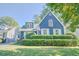 Attractive blue home featuring white trim, shutters, manicured bushes and a green lawn at 2195 Edison Ne Ave, Atlanta, GA 30305
