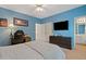 Comfortable bedroom with blue walls, ceiling fan, television and adjoining bathroom at 2329 Marion Walk Se Dr # 5, Atlanta, GA 30339
