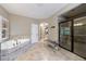 Bright bathroom featuring a corner bathtub and a frameless shower with neutral toned tile at 621 Oakbourne Way, Woodstock, GA 30188