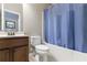 Cozy bathroom featuring a tub with blue shower curtain, toilet, and vanity with framed mirror at 621 Oakbourne Way, Woodstock, GA 30188