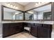 Bright bathroom featuring double sinks with granite countertops and dark wood cabinetry at 621 Oakbourne Way, Woodstock, GA 30188