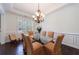 Elegant dining area with dark hardwood floors, a glass-top table, and ample natural light from plantation-shuttered windows at 621 Oakbourne Way, Woodstock, GA 30188