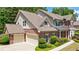 Side view of a stunning brick home featuring attached garage, well-manicured landscaping, and charming architectural details at 621 Oakbourne Way, Woodstock, GA 30188
