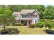 Beautiful two-story brick home with manicured lawn and mature trees at 621 Oakbourne Way, Woodstock, GA 30188