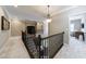 Upper hallway featuring a dark wood railing, chandelier, and view into adjacent rooms at 621 Oakbourne Way, Woodstock, GA 30188