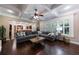 Bright living room featuring hardwood floors, a coffered ceiling, and a large sectional sofa at 621 Oakbourne Way, Woodstock, GA 30188