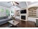 Spacious Gathering room with a fireplace, custom built-ins, and a large window showcasing the backyard at 621 Oakbourne Way, Woodstock, GA 30188