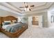 Spacious main bedroom with tray ceiling, ceiling fan, and open doorway to the upper hall at 621 Oakbourne Way, Woodstock, GA 30188