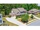 Rear exterior featuring a three car garage, extensive driveway and lush landscaping at 621 Oakbourne Way, Woodstock, GA 30188