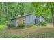 Angled side-view of a gray home with stone accents and lush, mature greenery at 1515 Barrier Rd, Marietta, GA 30066