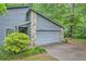 Two-car garage with gray wood facade and stone accents and concrete driveway at 1515 Barrier Rd, Marietta, GA 30066