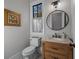 Powder room featuring a rustic vanity with granite top, unique round mirror and decorative lighting at 2373 Sagamore Hills Dr, Decatur, GA 30033