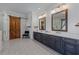A bathroom featuring double vanity sinks, shiplap walls, modern lights, barn door, patterned floors, and glass shower at 2373 Sagamore Hills Dr, Decatur, GA 30033