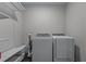 A laundry room area featuring a washing machine, a dryer, and storage shelving at 2373 Sagamore Hills Dr, Decatur, GA 30033