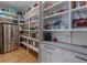 Walk-in pantry with white shelving, ample storage and full-sized stainless refrigerator at 2373 Sagamore Hills Dr, Decatur, GA 30033