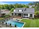 Wonderful backyard pool with shallow entrance and sunbathing chairs, adjacent to a covered patio and yard at 2373 Sagamore Hills Dr, Decatur, GA 30033